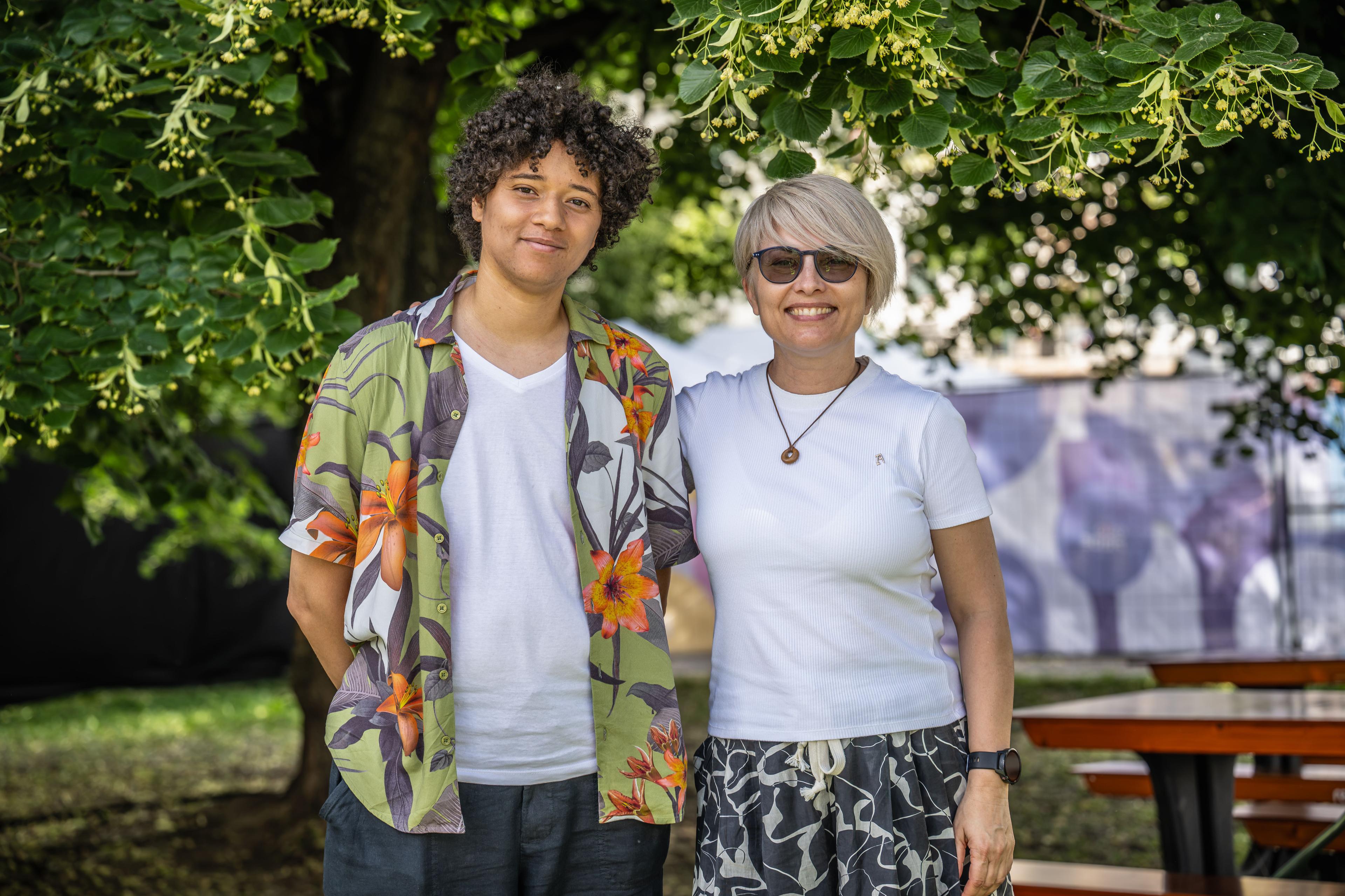 Leo Zbancă og Angela Frolov fra Genderdoc-M står smilende sammen under et tre i en park.